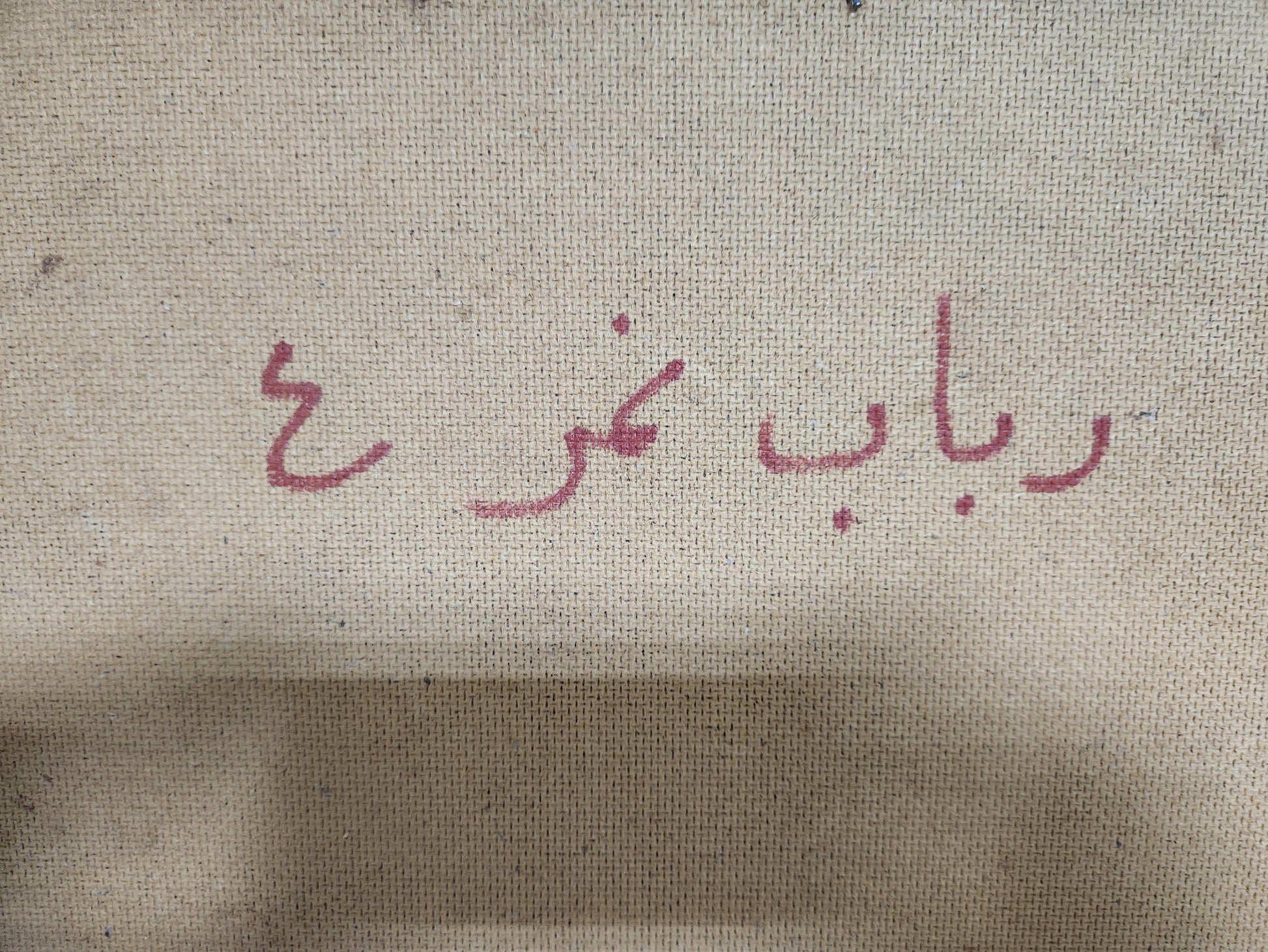 Reverse of the canvas inscribed in red in Arabic: Rabab Nemr