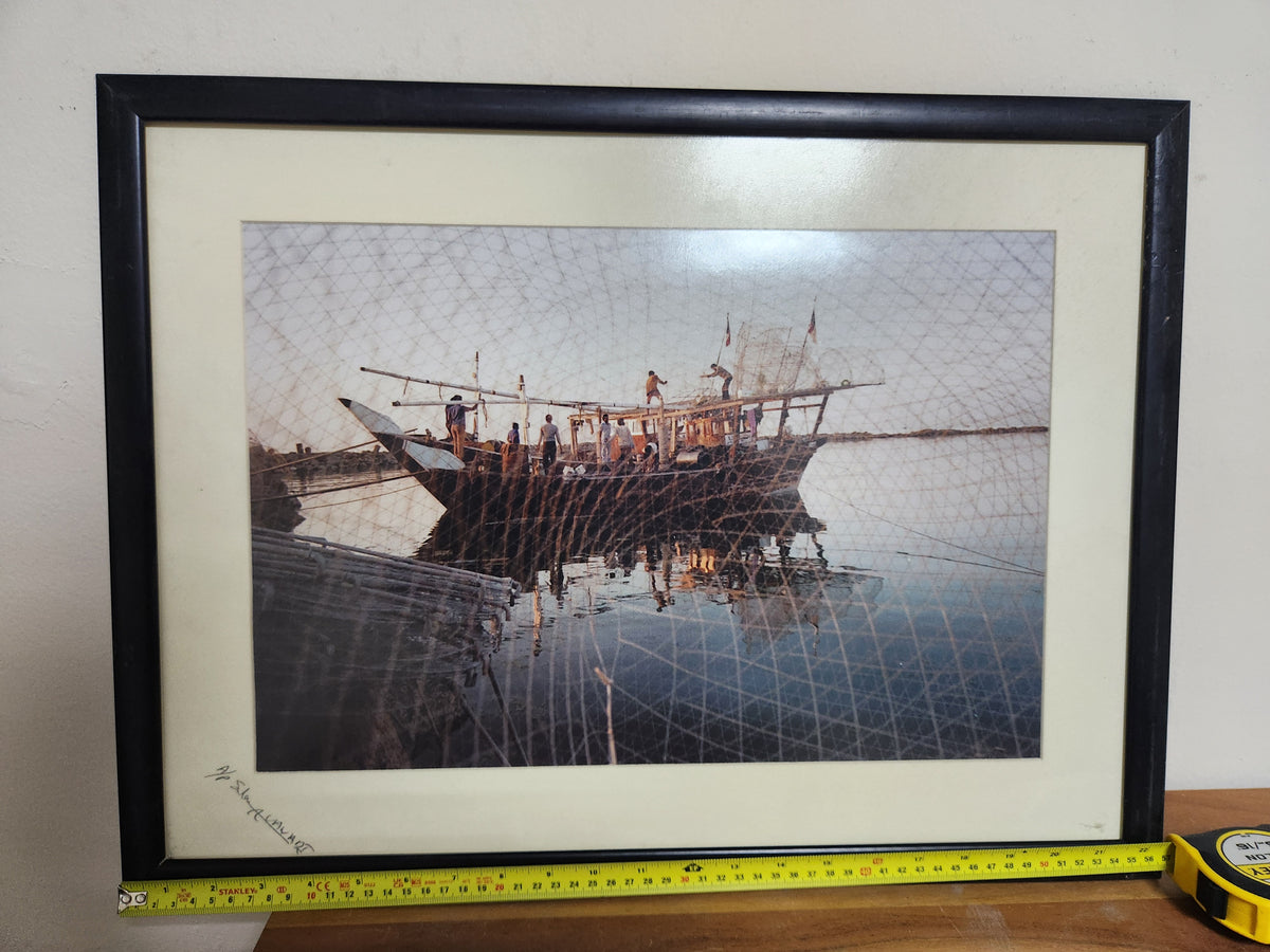 Signed artist's proof photograph of a Kuwaiti dhow seen through a fishing net, framed, shown with tape measure for width